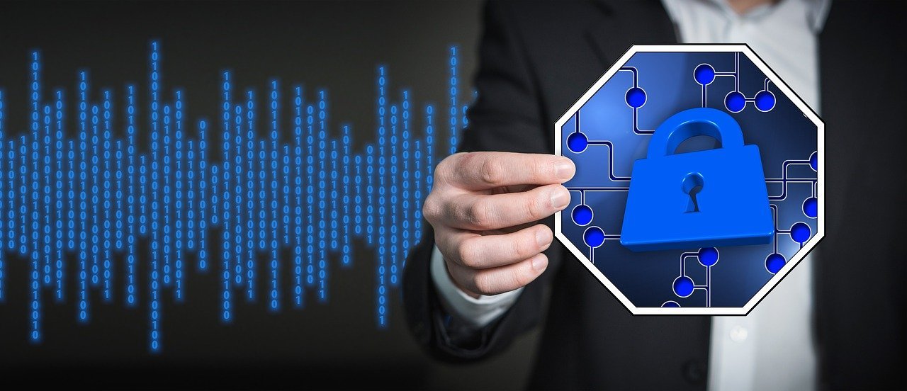 Businessman holds graphic representing software security in front of matrix code screen