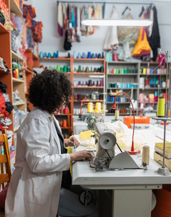 Photo showing a woman in a sewing factory.