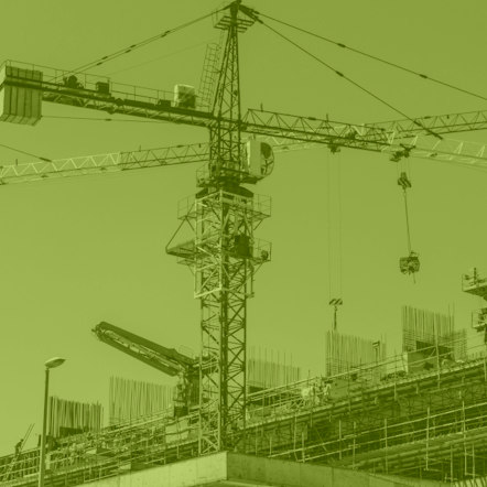 Photo of a construction site and a large crane that is greyscale with a lime green filter.