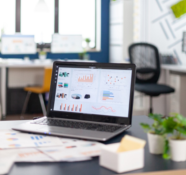 Office and laptop on a desk photo, showing modern software on the laptop screen.