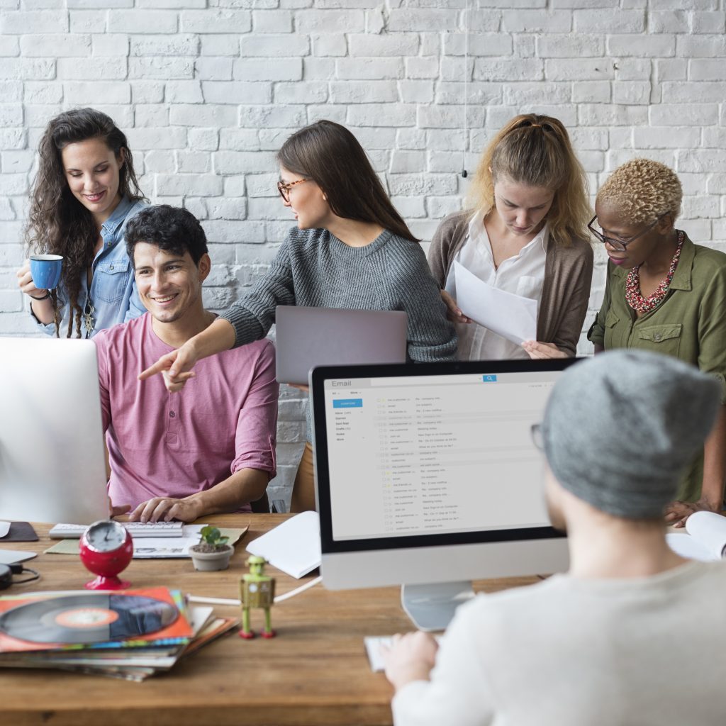 Group of people in an office looking at a monitor, to represent who will be affected, if you introduce new software to your company.