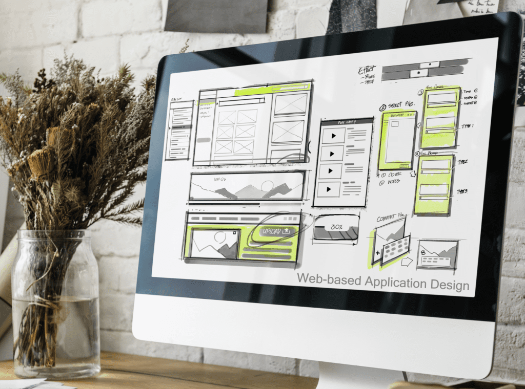 Photo of a computer monitor on the screen is a mockup of web-based application software.