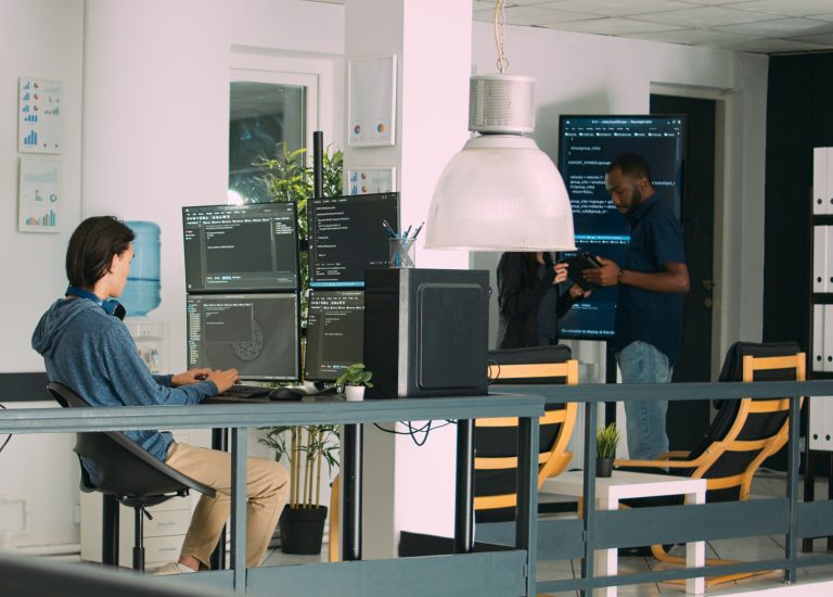 Image of a people work in a software development companies office. To represent the advantages and disadvantages of bespoke software.
