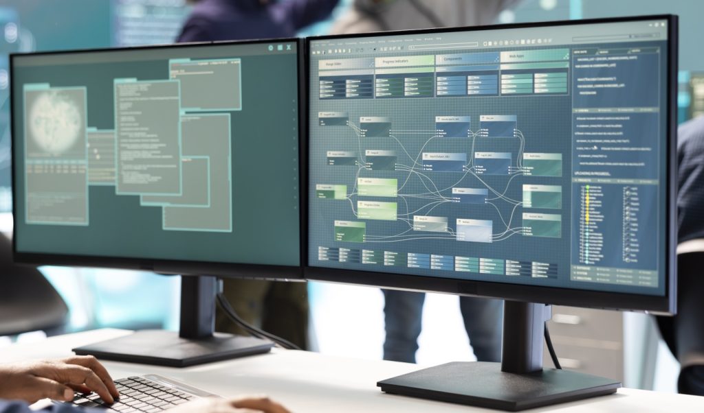 Photo showing monitors with code on them bespoke software solutions