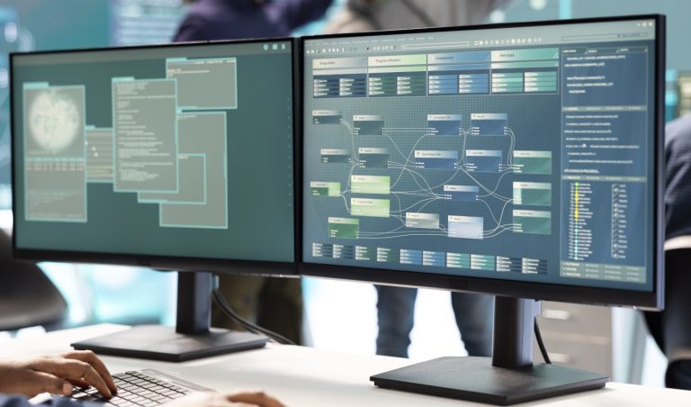 Photo showing monitors with code on them bespoke software solutions