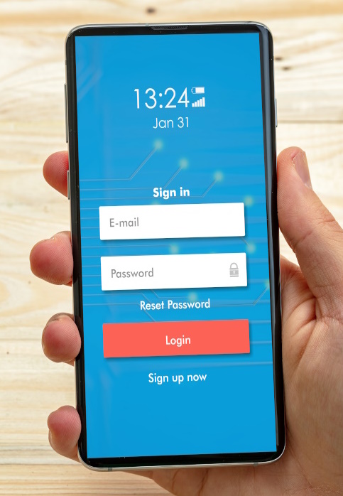 Photo of a hand holding a mobile phone with login screen.
