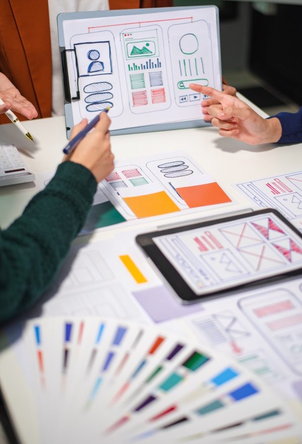Photo of a team designing a mobile application screens, on paper.