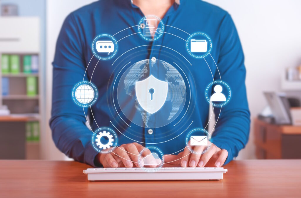 Photo of a man using a keyboard with floating icons of security to represent what is data security.