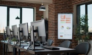Photo of an office with computers, monitors headphones to represent IT Hardware.